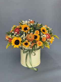Шляпная коробка из подсолнуха, леукоспермума, танацетума, эрингинума, альстромерии, кустовой розы и солидаго